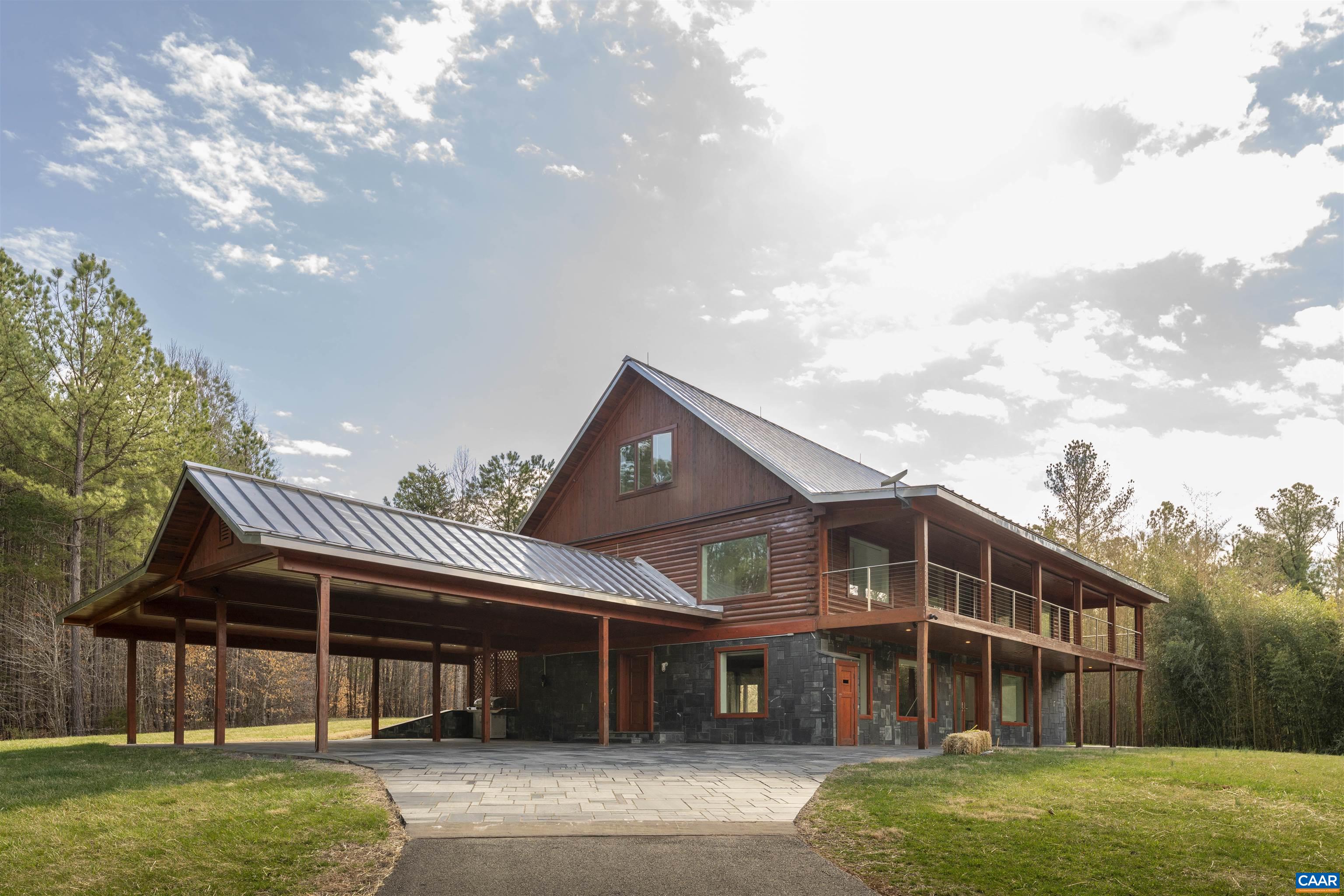 a front view of a house with a garden and lake view