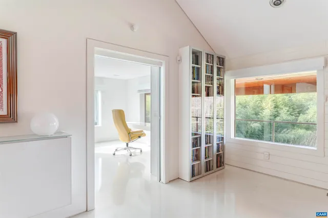 a view of a workspace with furniture and a window