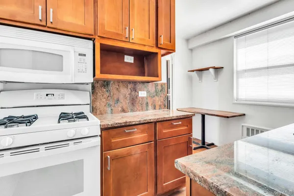 a kitchen with stainless steel appliances granite countertop a stove and a microwave