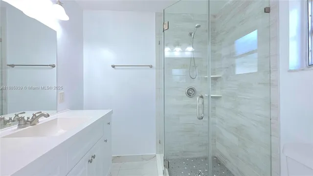 a bathroom with a shower sink and mirror