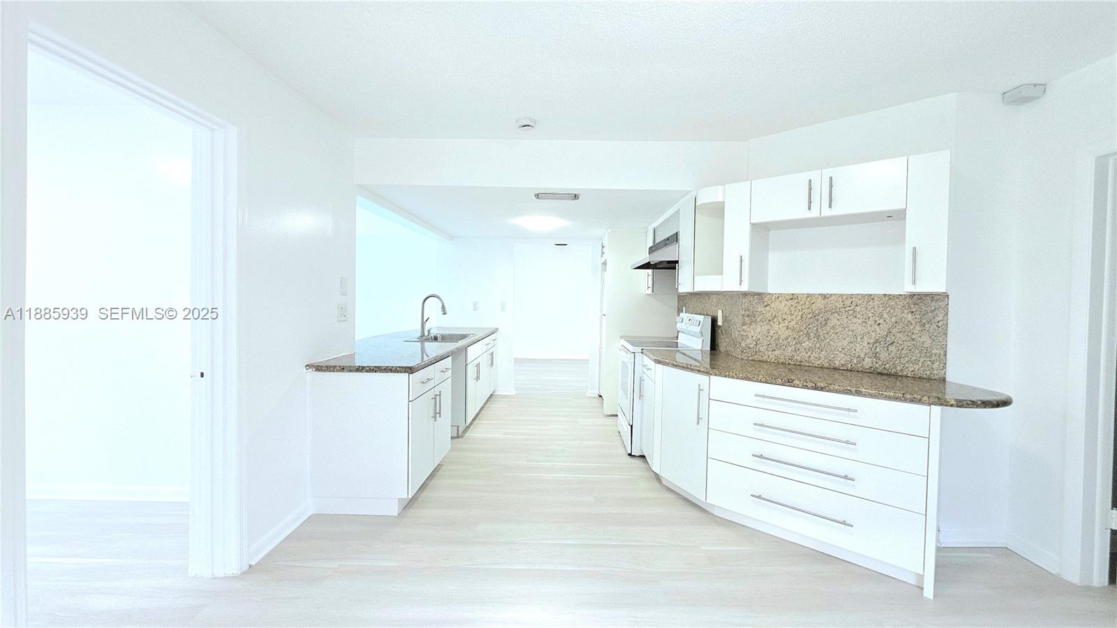 5300 Southwest 7th Court Margate, FL 33068 - Photo 6 of 18 a large white kitchen with kitchen island a sink stainless steel appliances and cabinets