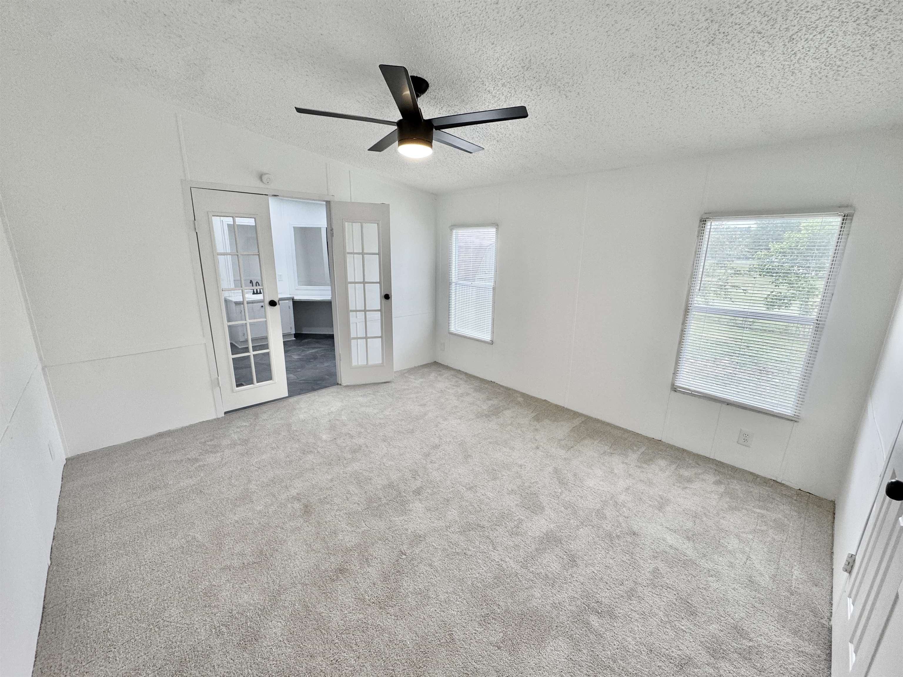 841 Simmons Road Drummonds, TN 38023 - Photo 16 of 35 Unfurnished bedroom with french doors, a textured ceiling, carpet floors, vaulted ceiling, and a ceiling fan