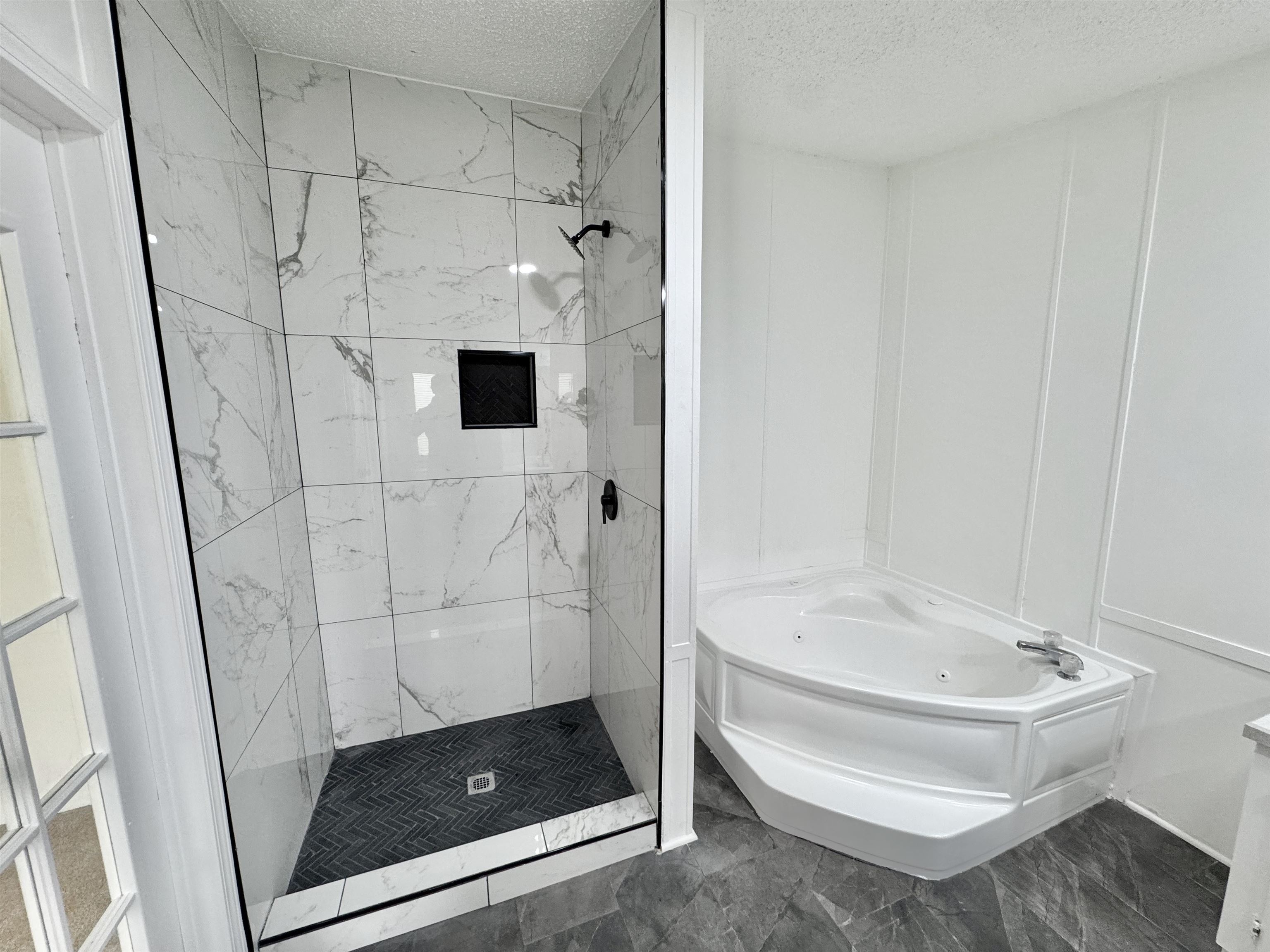 841 Simmons Road Drummonds, TN 38023 - Photo 20 of 35 Full bathroom featuring marble look tiles, a textured ceiling, a decorative wall, a shower stall, and a tub with jets