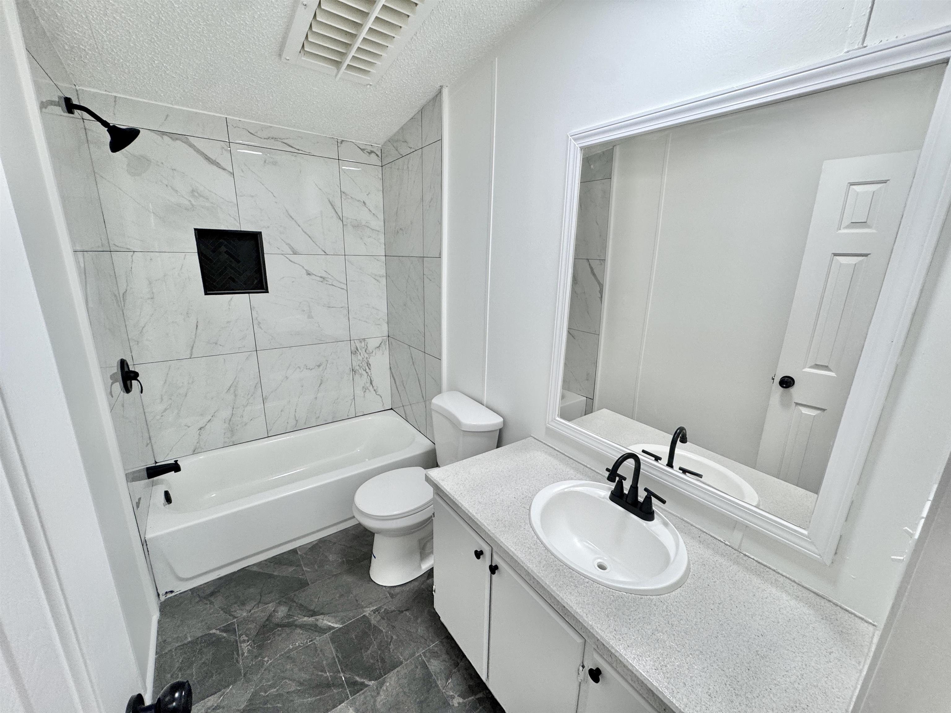 841 Simmons Road Drummonds, TN 38023 - Photo 23 of 35 Full bathroom featuring a textured ceiling, toilet, tub / shower combination, and vanity