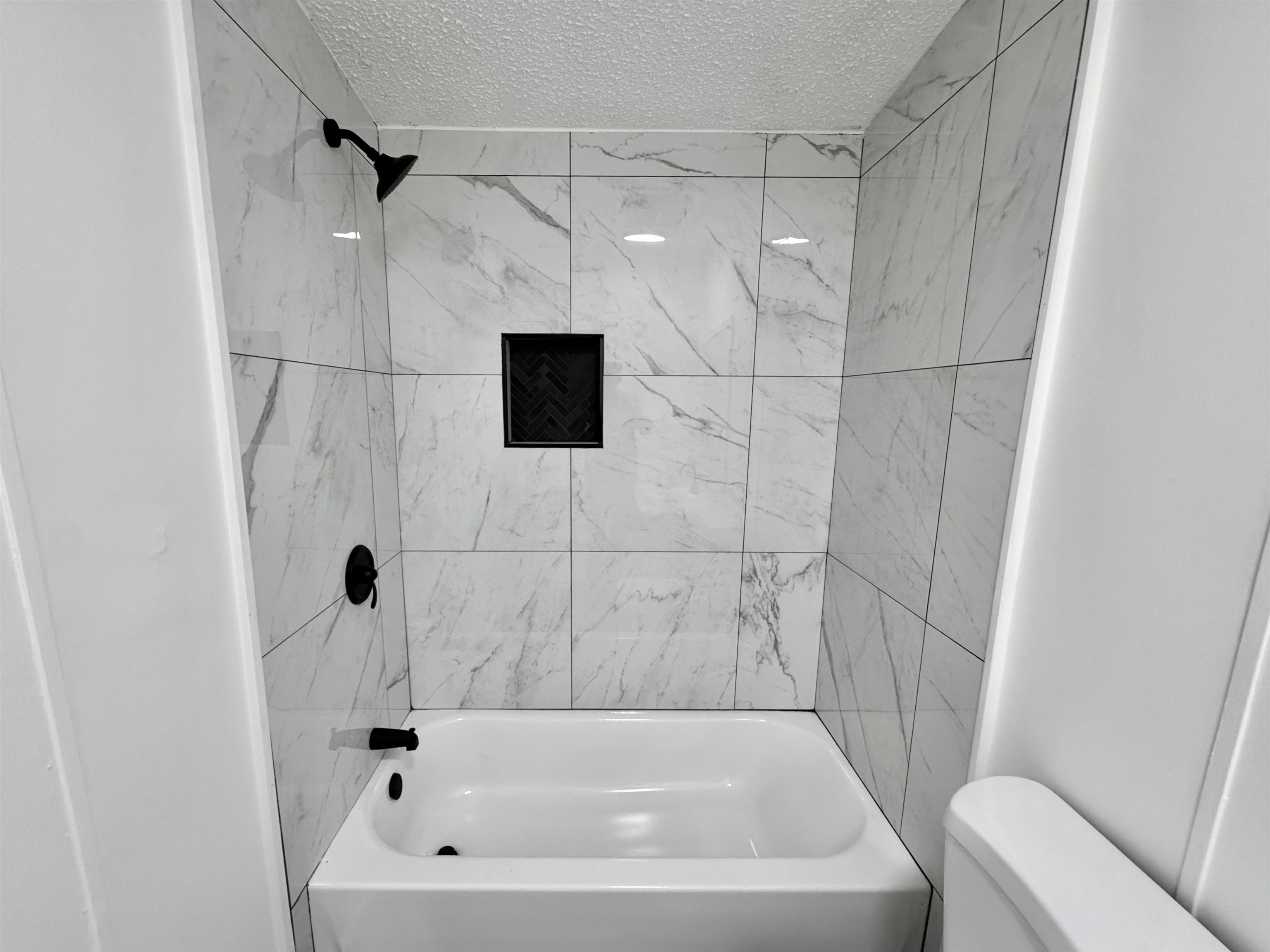841 Simmons Road Drummonds, TN 38023 - Photo 24 of 35 Full bath with a textured ceiling, toilet, and washtub / shower combination