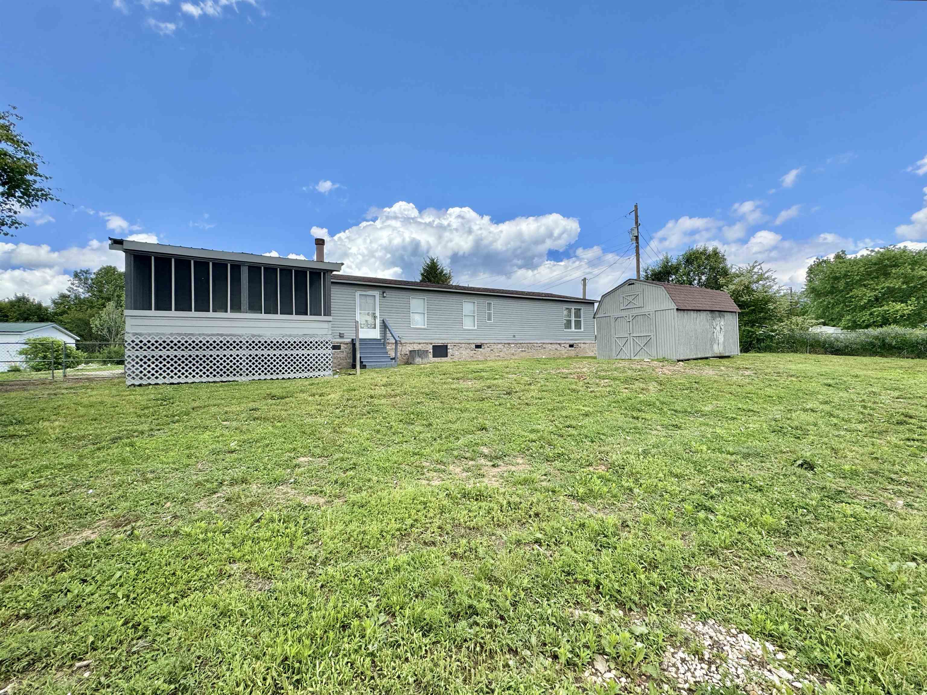 841 Simmons Road Drummonds, TN 38023 - Photo 31 of 35 Rear view of property featuring entry steps, a sunroom, an outdoor structure, and a yard