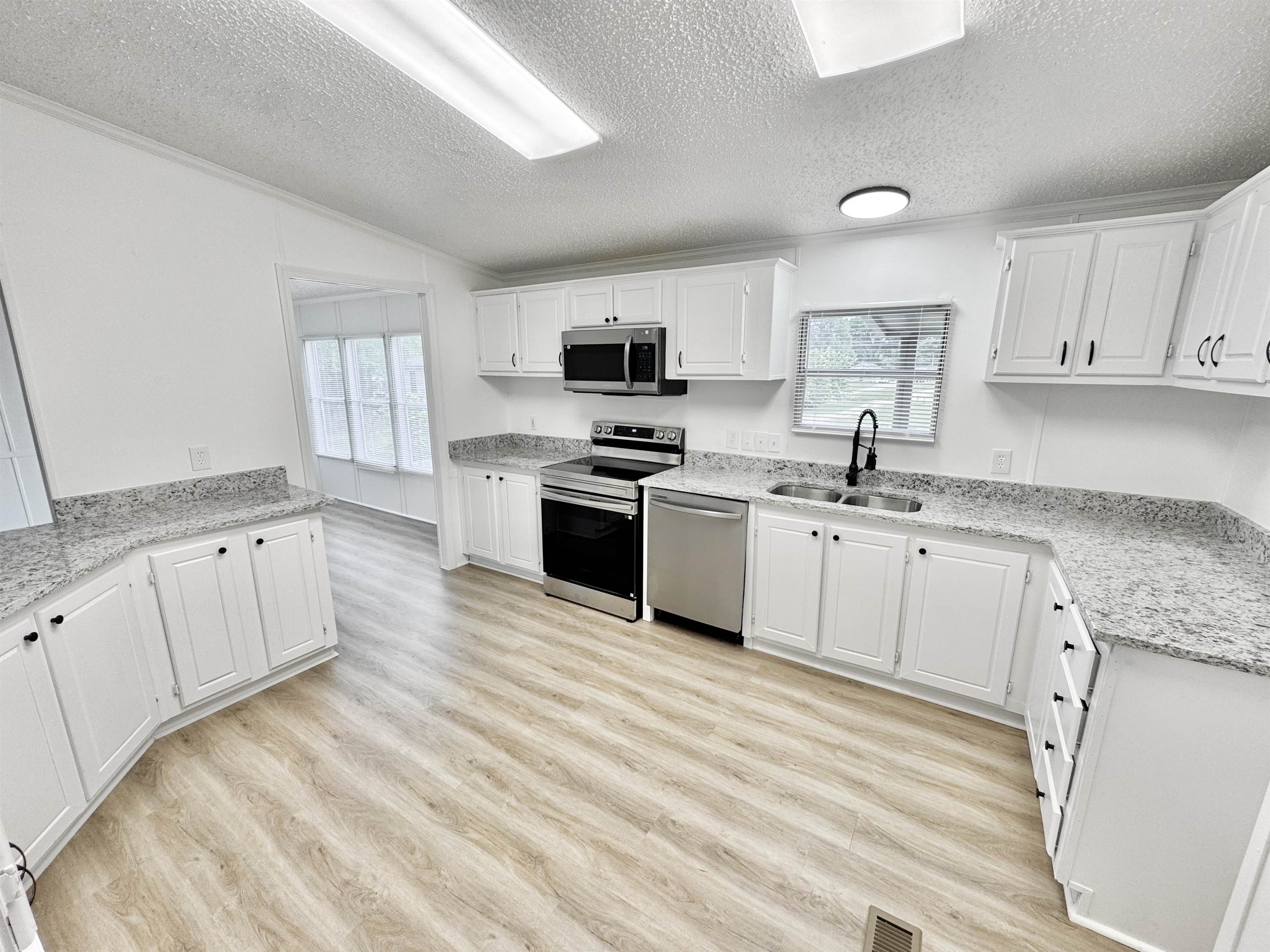 841 Simmons Road Drummonds, TN 38023 - Photo 5 of 35 Kitchen with appliances with stainless steel finishes, a sink, plenty of natural light, light wood-type flooring, and a textured ceiling