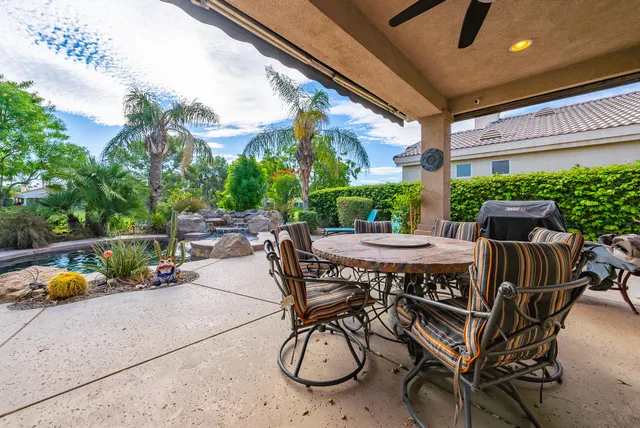 a table and chairs with potted plants in front of it
