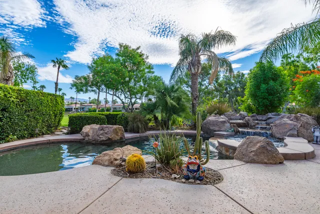 a couple of cars parked in front of yellow house