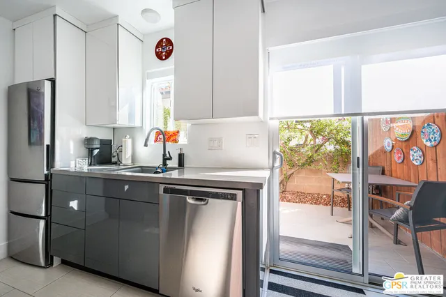 a kitchen with stainless steel appliances granite countertop a sink and a refrigerator