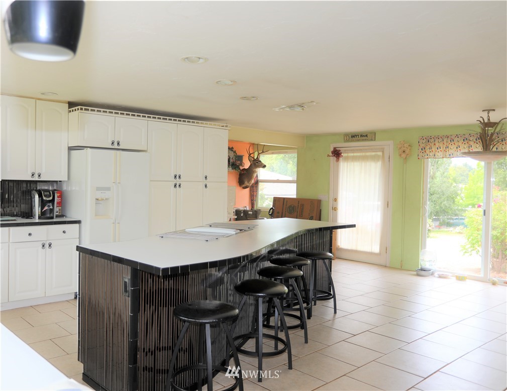 11204 Southeast Petrovitsky Road Renton, WA 98055 - Photo 11 of 37 a kitchen with stainless steel appliances a table chairs and a refrigerator