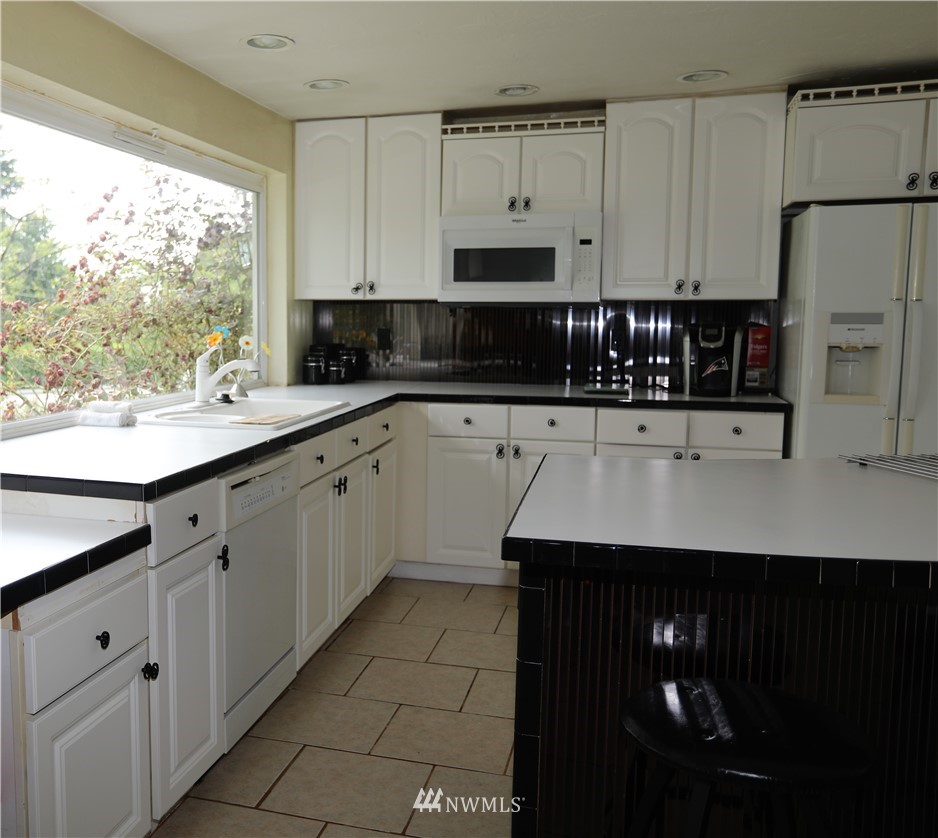 11204 Southeast Petrovitsky Road Renton, WA 98055 - Photo 9 of 37 a kitchen with stainless steel appliances a sink cabinets and a window