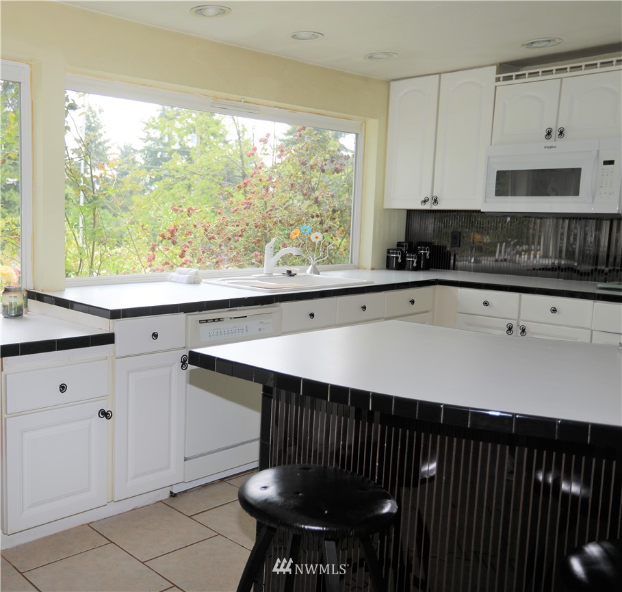 11204 Southeast Petrovitsky Road Renton, WA 98055 - Photo 10 of 37 a kitchen with a sink a window and cabinets