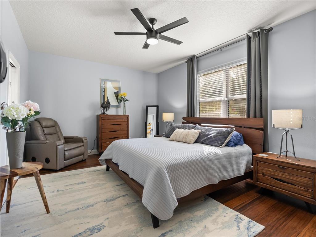 30021 Donnington Loop Mount Dora, FL 32757 - Photo 18 of 40 a bedroom with a bed and dresser with wooden floor