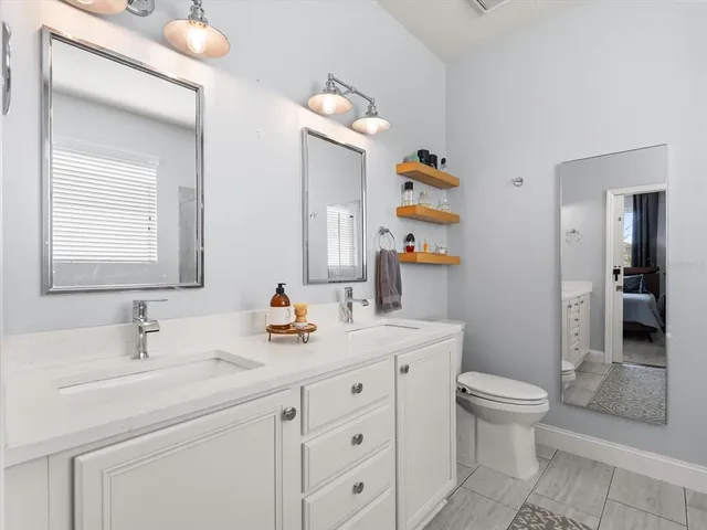 a bathroom with a sink a toilet and a mirror