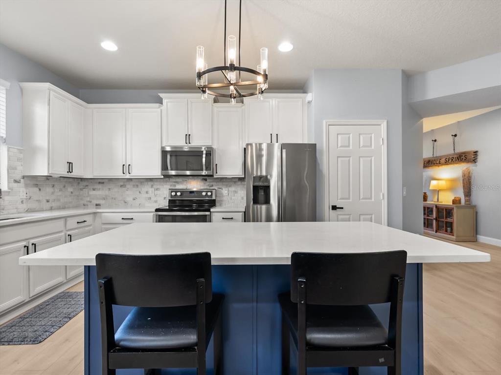 30021 Donnington Loop Mount Dora, FL 32757 - Photo 10 of 40 a kitchen with a dining table cabinets appliances and a counter top space