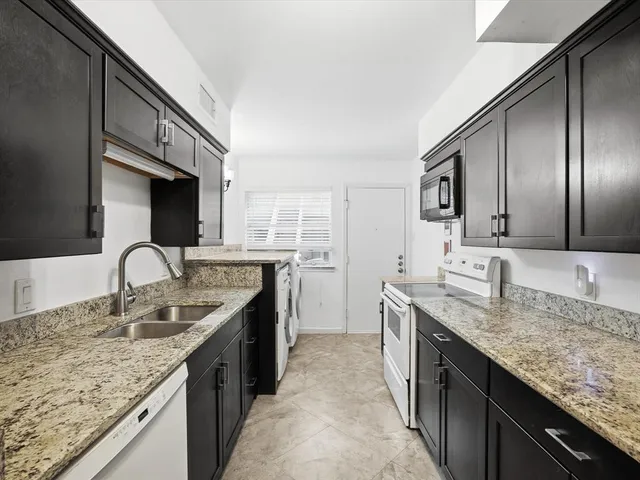 a kitchen with stainless steel appliances granite countertop a sink stove and cabinets