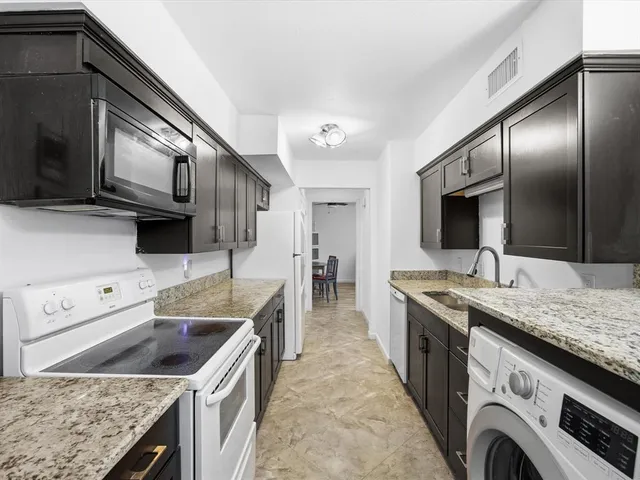 a kitchen with stainless steel appliances granite countertop a sink and a stove