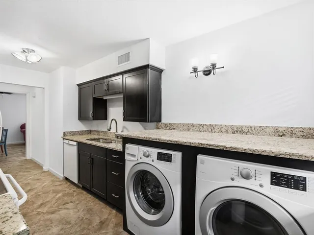 a view of a kitchen with sink washer and dryer