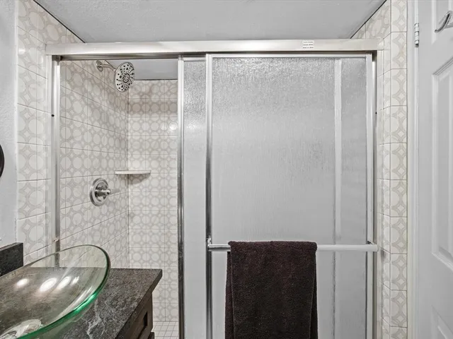 a bathroom with a granite countertop shower and a sink