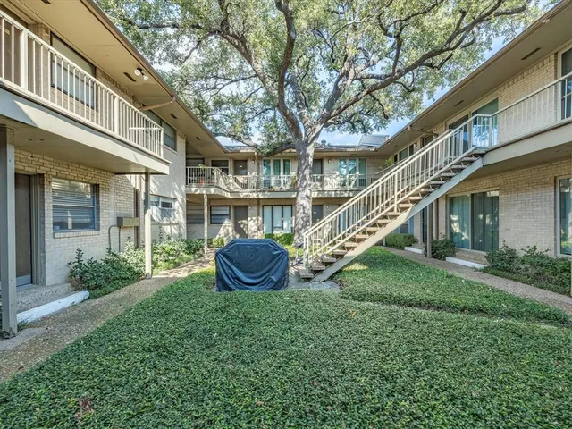 a view of an house with backyard and a tree