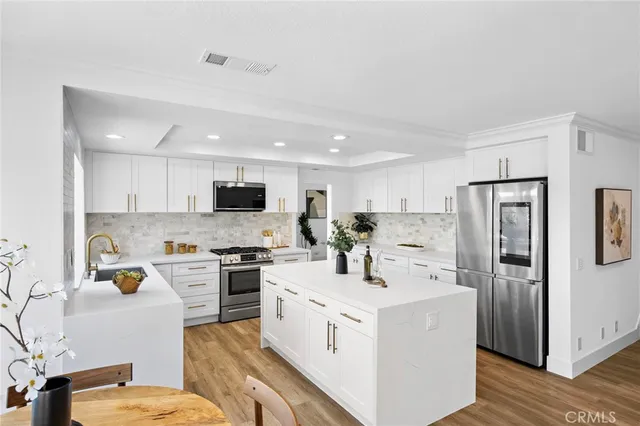 a kitchen with stainless steel appliances a stove refrigerator sink and microwave