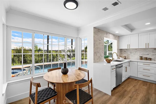 a kitchen with a stove a sink and white cabinets