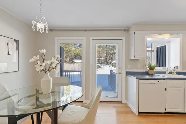 a dining room with chandelier and wooden floor