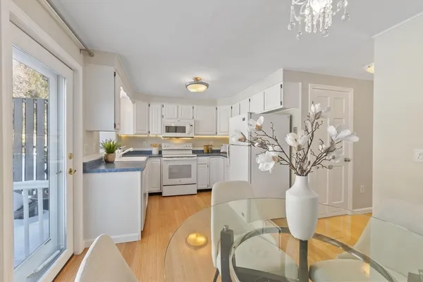 a living room with stainless steel appliances kitchen island granite countertop furniture and a chandelier