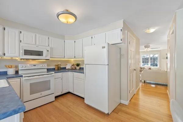 a kitchen with white cabinets and white appliances