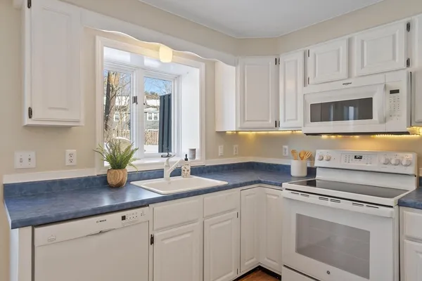 a kitchen with stainless steel appliances granite countertop white cabinets a sink and dishwasher