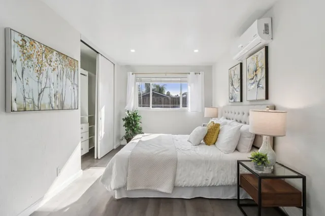 a bedroom with a large bed and a painting on the wall