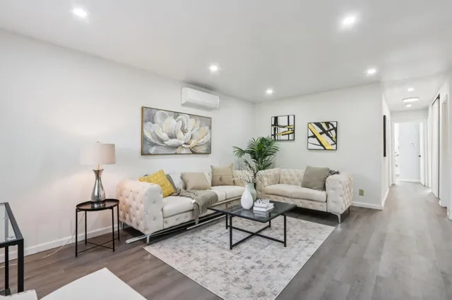 a living room with furniture and wooden floor