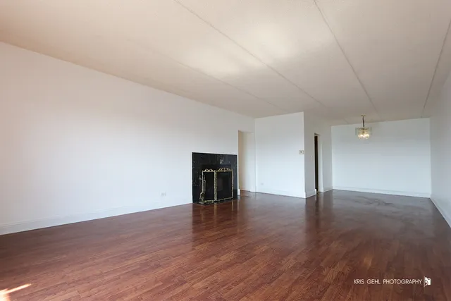 an empty room with wooden floor and fireplace