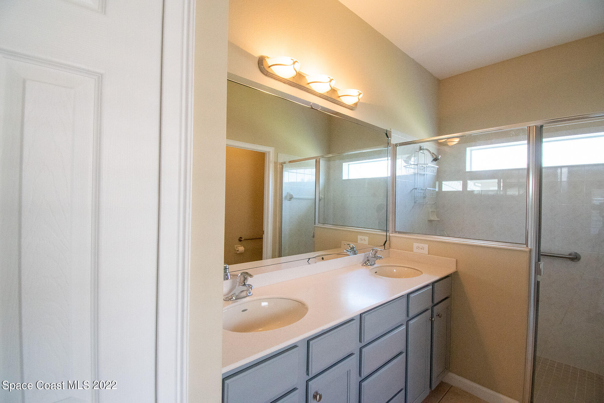 4165 Alamanda Key Drive Melbourne, FL 32901 - Photo 21 of 38 a bathroom with a granite countertop sink a large mirror and shower
