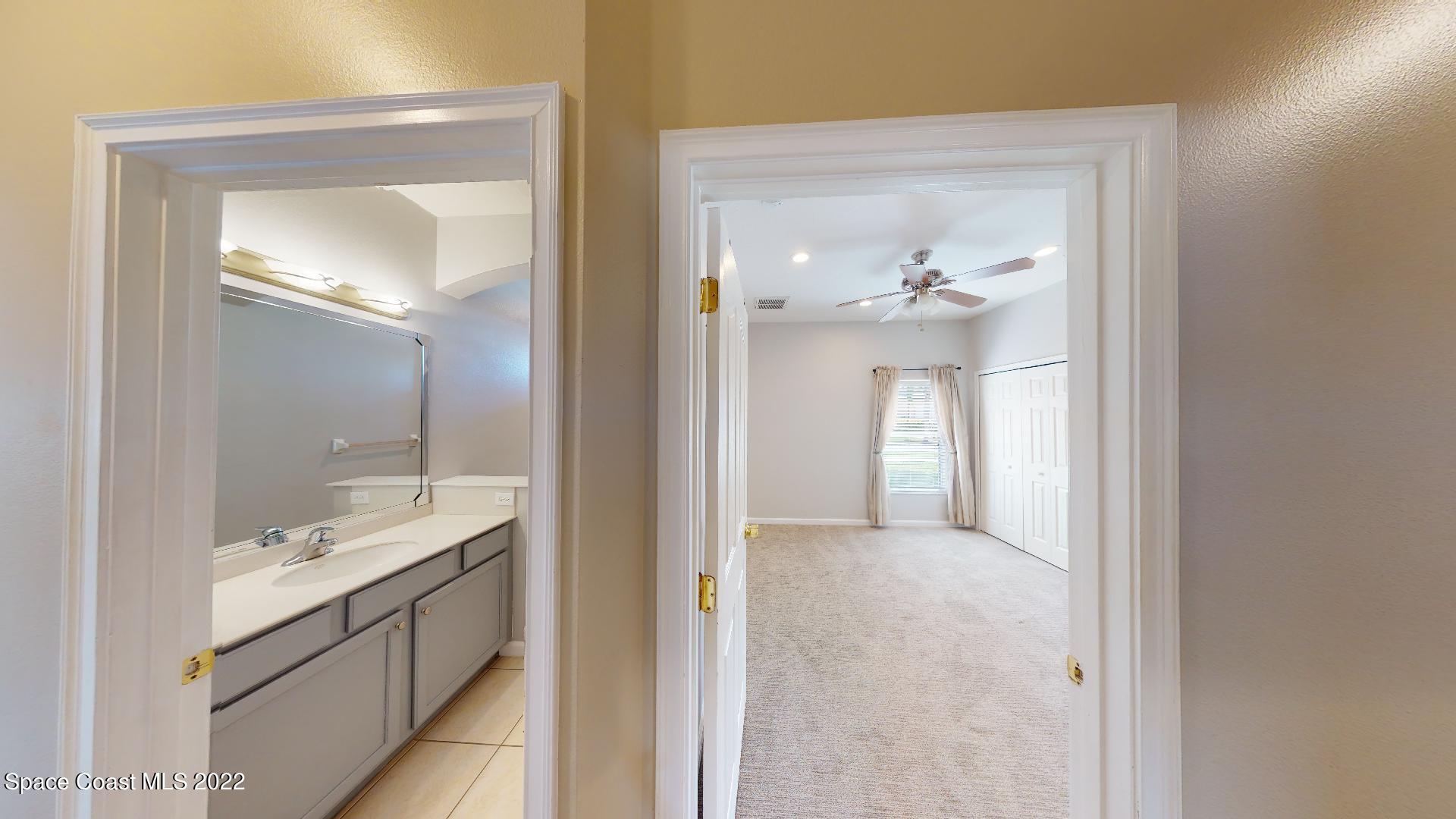 4165 Alamanda Key Drive Melbourne, FL 32901 - Photo 26 of 38 a bathroom with a granite countertop sink a mirror and a vanity