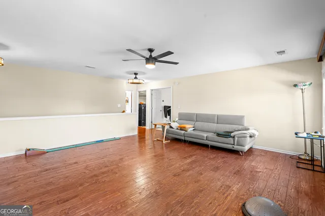 a living room with a bed and a ceiling fan