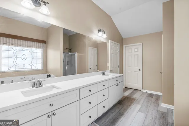 a bathroom with a tub a sink and a shower