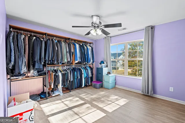 a view of walk in closet with clothes and shoes