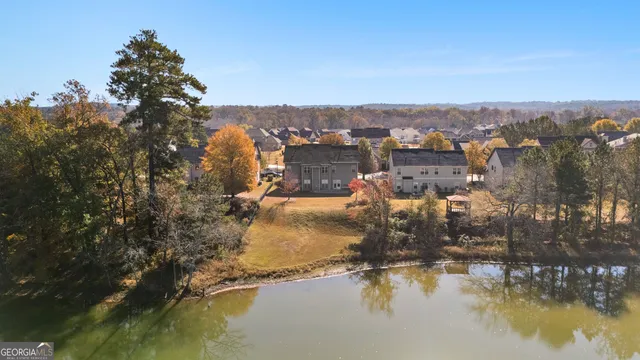 an aerial view of residential houses with outdoor space and lake view