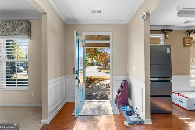 a view of hallway with wooden floor and furniture