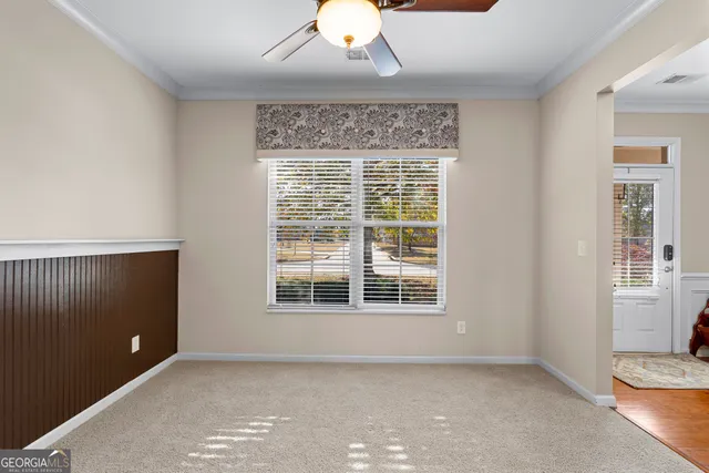 a view of an empty room with a window and cabinet