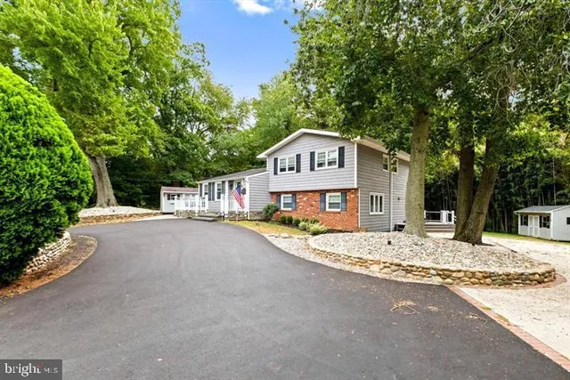 a view of a house with a yard and large tree