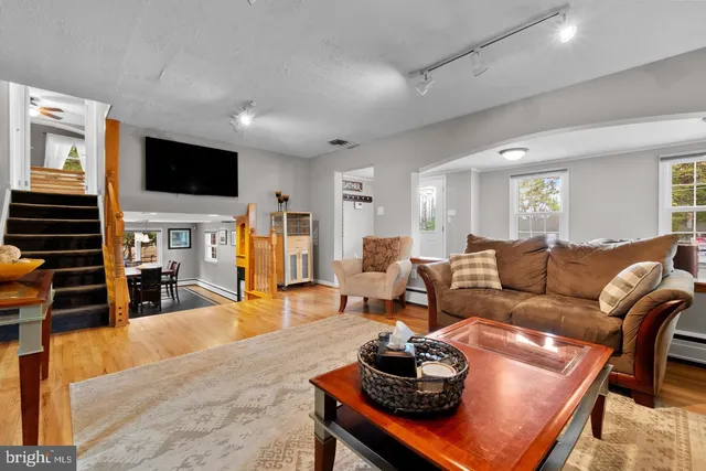 a living room with furniture a flat screen tv and kitchen view