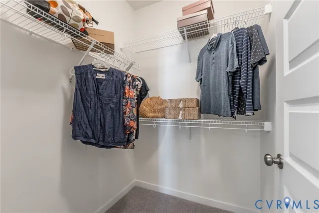 a view of walk in closet with clothes and shoes