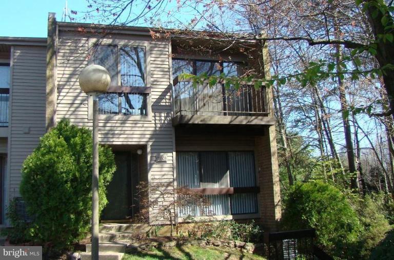 a front view of a house with garden and plants