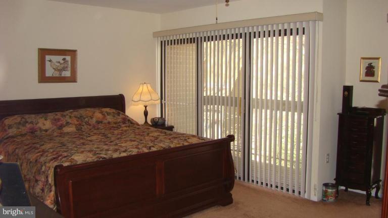 11603 Windbluff Court Reston, VA 20191 - Photo 9 of 22 a bed sitting in a bedroom next to a window