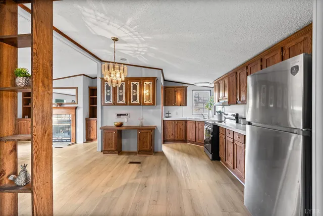 a kitchen with a refrigerator a stove top oven a sink dishwasher and wooden floor