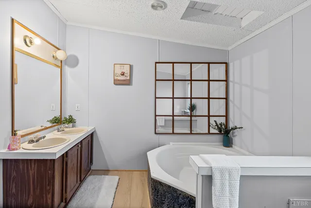 a bathroom with a double vanity sink a mirror and a bathtub