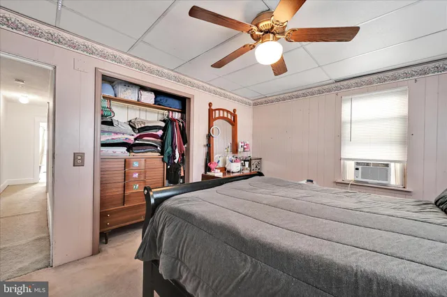 a bedroom with a bed dresser and a window